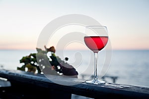 A glass of red wine at sunset on terrace