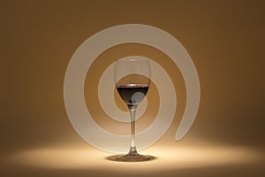 Glass of red wine on a warm background created with intimate lighting