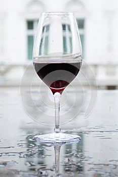 Glass of red wine on a watery surface