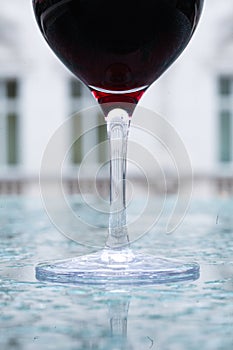 Glass of red wine on a watery surface