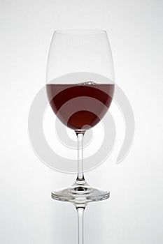 Glass with red wine on a white background