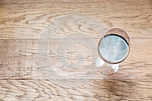 Glass with red wine on the wooden background