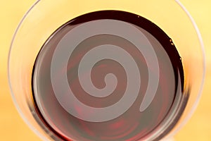 Glass of red wine on wooden background, close up.