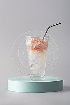 Glass of refreshing cocktail with grapefruit on the podium, still life,