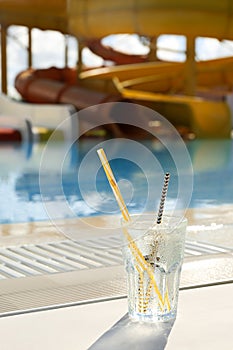 Glass of drink near swimming pool