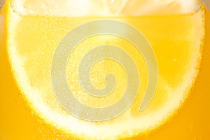 Glass of refreshing drink with sliced lemon on light background, closeup