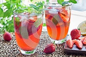 Glass of refreshing iced tea with strawberries and mint, horizon