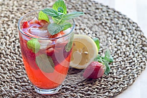 Glass of refreshing iced tea with strawberries and mint, horizon