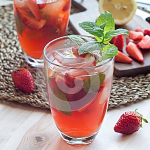 Glass of refreshing iced tea with strawberries and mint, square