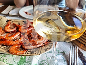 Glass of ribeiro wine and grilled prawns in a restaurant in Olveiroa village, Dumbria municipality, Galicia, Spain photo