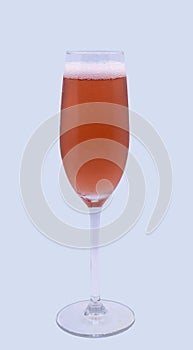 A glass of rose pink champagne with bubbles and foam