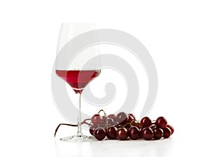 Glass of rose wine with bunch of grape isolated on white