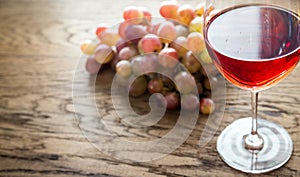 Glass of rose wine with bunch of grape