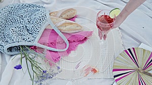 A Glass Of Rose Wine in a luxury romantic picnic date on a white blanket at the beach - Close Up Sh