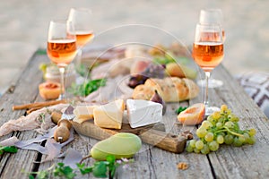 Glass of rose wine on picnic table.