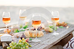 Glass of rose wine on picnic table.