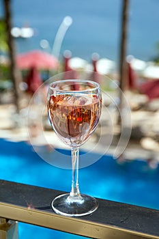 Glass of rose wine with sea and pool view