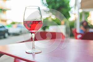 Glass of rose wine on the table in street cafe Vintage toning Selective focus