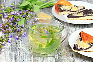 Glass of sage herbal tea with cake