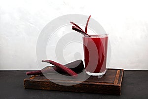 Glass of Salgam on wooden cutting board. Popular Turkish drink. Traditional beverage made with water, purple carrot or turnip