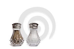 Glass Salt and Pepper Shakers with Silver Metal Lids on White Background with Copy Space