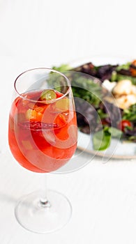 Glass of sangria accompanied by salad