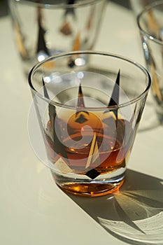 Glass of scotch whiskey or cognac on bright background with copy space