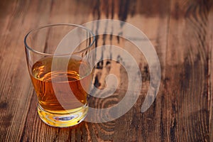 A glass of Scotch or whiskey on a wooden texture background