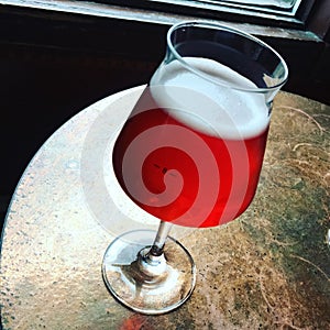 Glass of seasonal cherry beer on a bar table