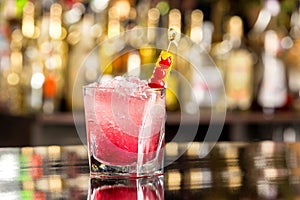 Glass of shirley temple cocktail decorated with cherry and frappe photo