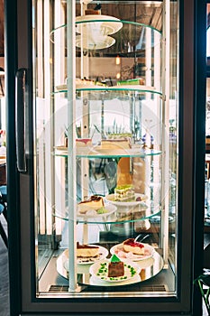 Glass showcase refrigerator with desserts inside.