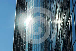 A glass skyscraper with the sun glistening photo