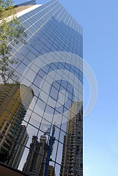 Glass skyscraper tall modern building, reflection, blue sky, vertical