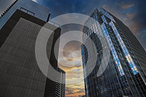 Glass skyscrapers and office buildings in the city skyline with powerful clouds and blue sky at sunset in downtown Nashville