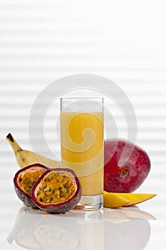 glass of smoothie with mango passion fruit and banana, close up.