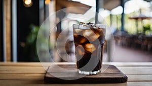 A glass of soda with ice on a wooden table