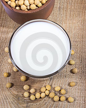 Glass of soy milk on a wooden background.