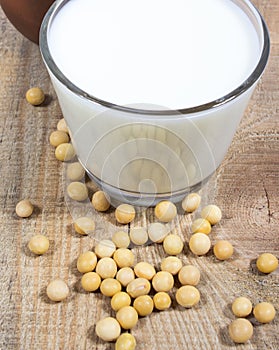 Glass of soy milk on a wooden background.