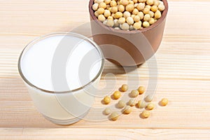 Glass of soy milk on a wooden background.