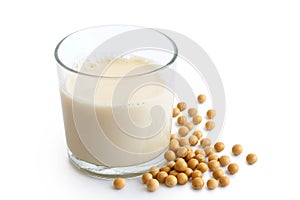 Glass of soya milk with froth isolated on white. Spilled soya be