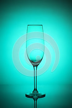 Glass of sparkling champagne on cyan background