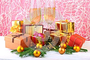 Glass of sparkling shampagne wine, clock, gift box and candles on christmas background.