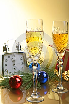 Glass of sparkling shampagne wine clock and gift box on christmas background