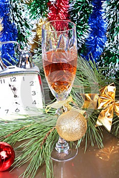 Glass of sparkling shampagne wine clock and gift box on christmas background