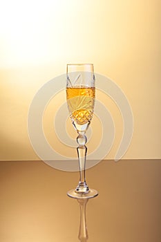 Glass of sparkling shampagne wine on a gold background