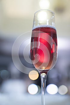 Glass of sparkling wine with bubbles on bokeh background