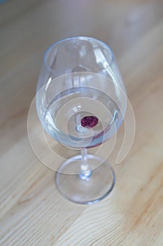 A glass of sparkling wine on a wooden table against