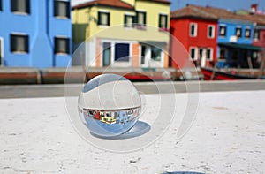 Glass sphere  in Burano and colourfully houses near Venice