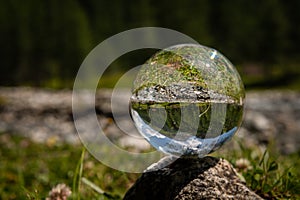 Glass sphere lying on a rock, river in Austrian alps