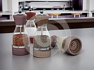 Glass spice grinders set standing on kitchen table. 3D illustration